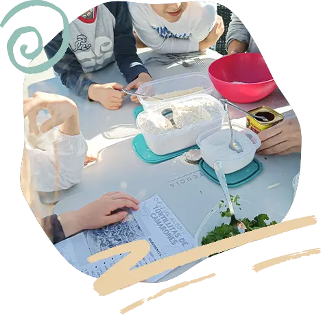 Alumnos trabajan en una mesa al aire libre con lupas y cuadernos