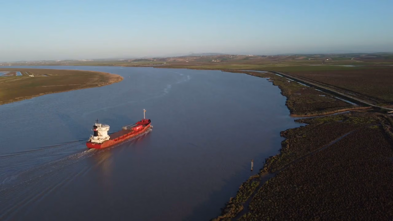 Un barco navega por el Guadalquivir entre las marismas, visto desde el aire