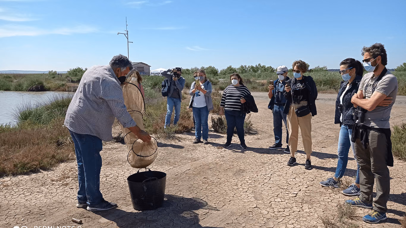 Un trabajador del estero enseña el despesque con atarraya a un grupo de visitantes